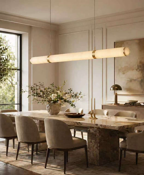 A linear alabaster pendant light hangs above the dining room table; the light is 1.5 metres long and is made of alabaster and gold-coloured copper.