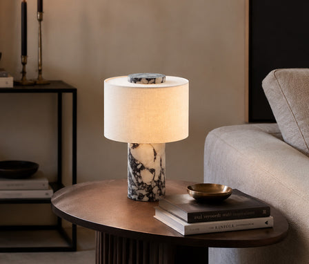 Luxurious Calacatta white marble table lamp resting on a modern living room coffee table.
