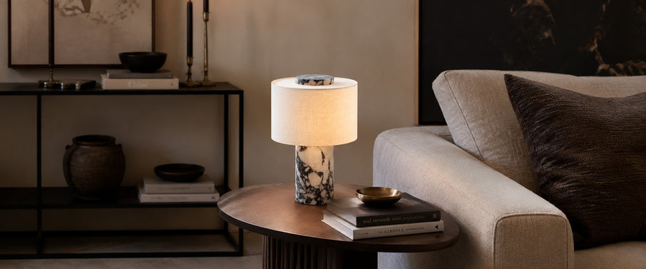 Luxurious Calacatta white marble table lamp resting on a modern living room coffee table.