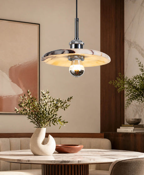 A pendant light designed for a dining table seating four people is crafted from silver metal and Calacatta marble.