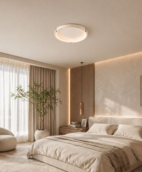 A Wabi-sabi-style 65cm diameter round yellow travertine bedroom ceiling light above a 1.8-metre bed with an off-white duvet cover.