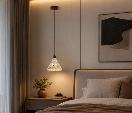 Modern terrazzo stone table lamp serving as cozy bedside lighting in a bedroom.