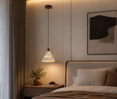 Modern terrazzo stone table lamp serving as cozy bedside lighting in a bedroom.